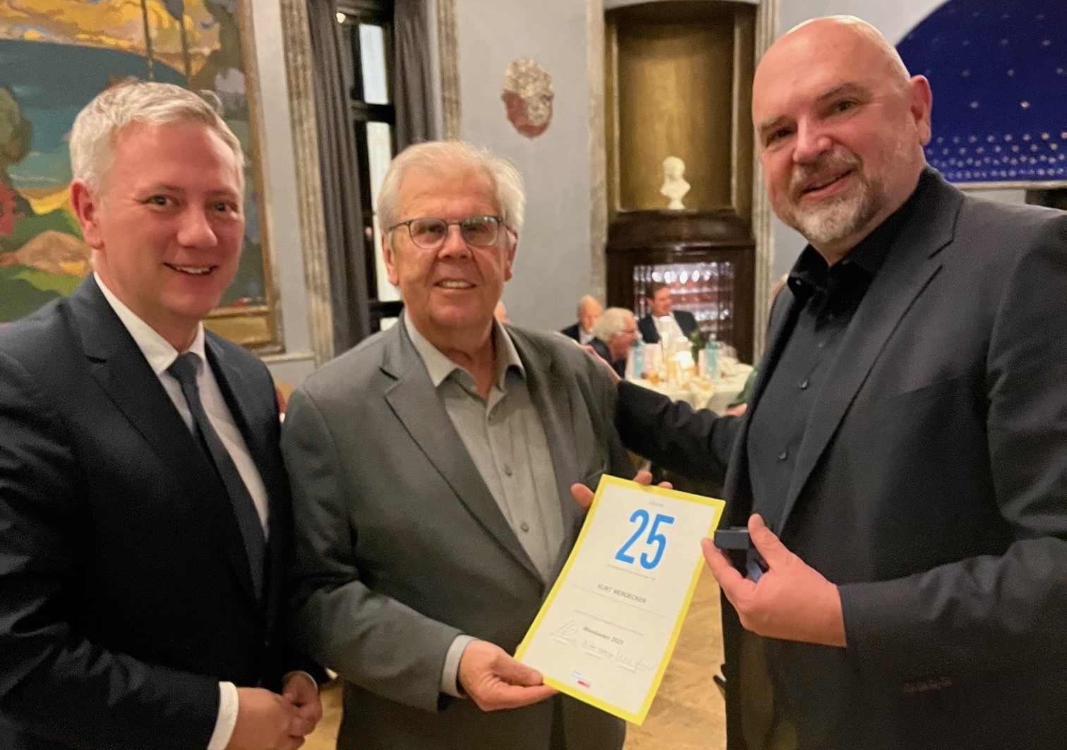 Moritz Promny und Mathias Zeuner überreichen Kurt Werdecker eine Urkunde